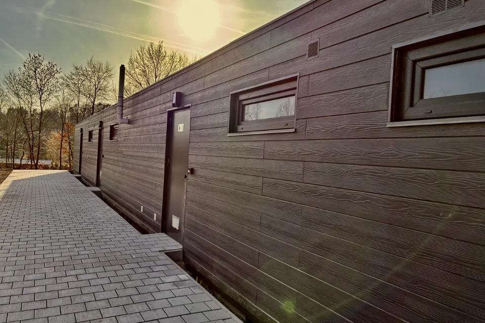 The sanitary building from outside with its anthracite wood-structure facade
