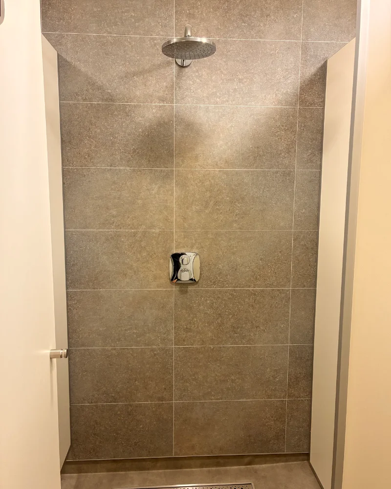 Level-access shower with rain head and thermostat