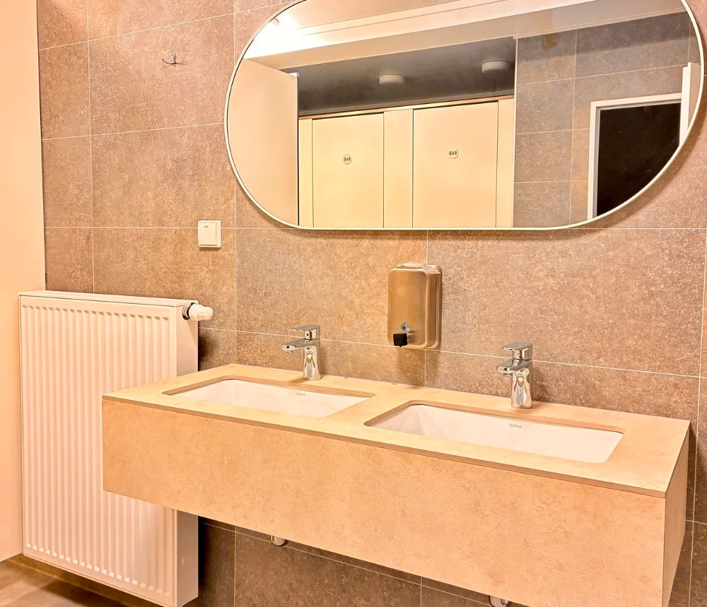 Washroom with double washbasin, large mirror and radiator